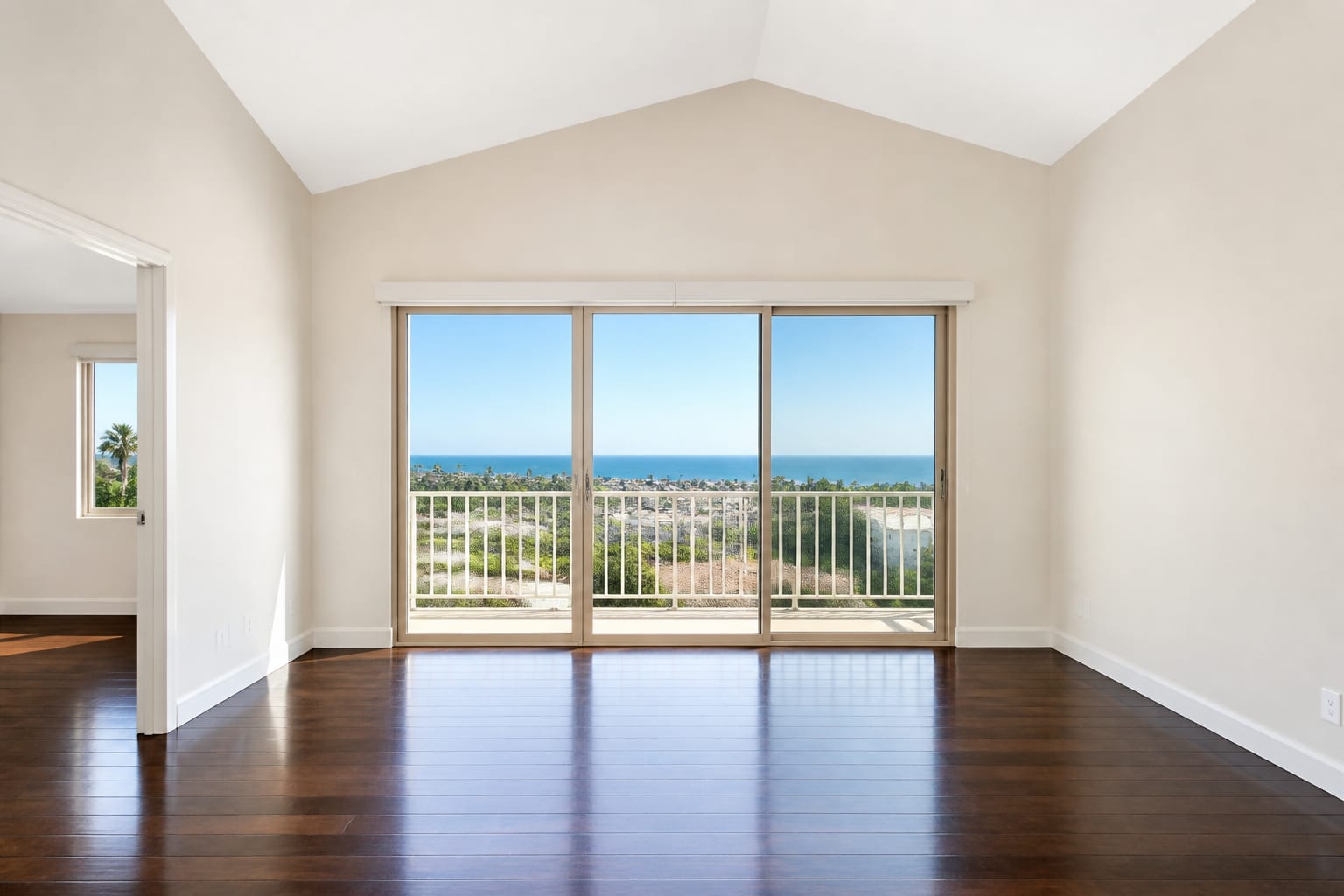 Empty interior with dark floors and a slider opening to an ocean view