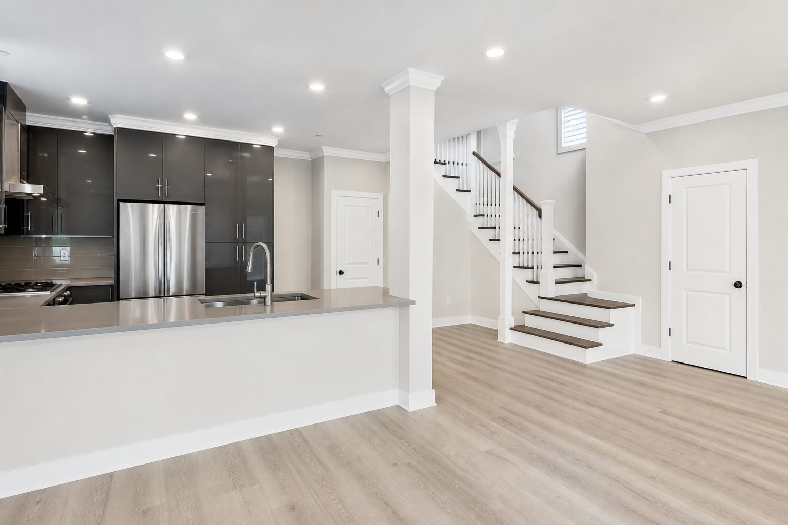 Kitchen peninsula and staircase in a renovated coastal home
